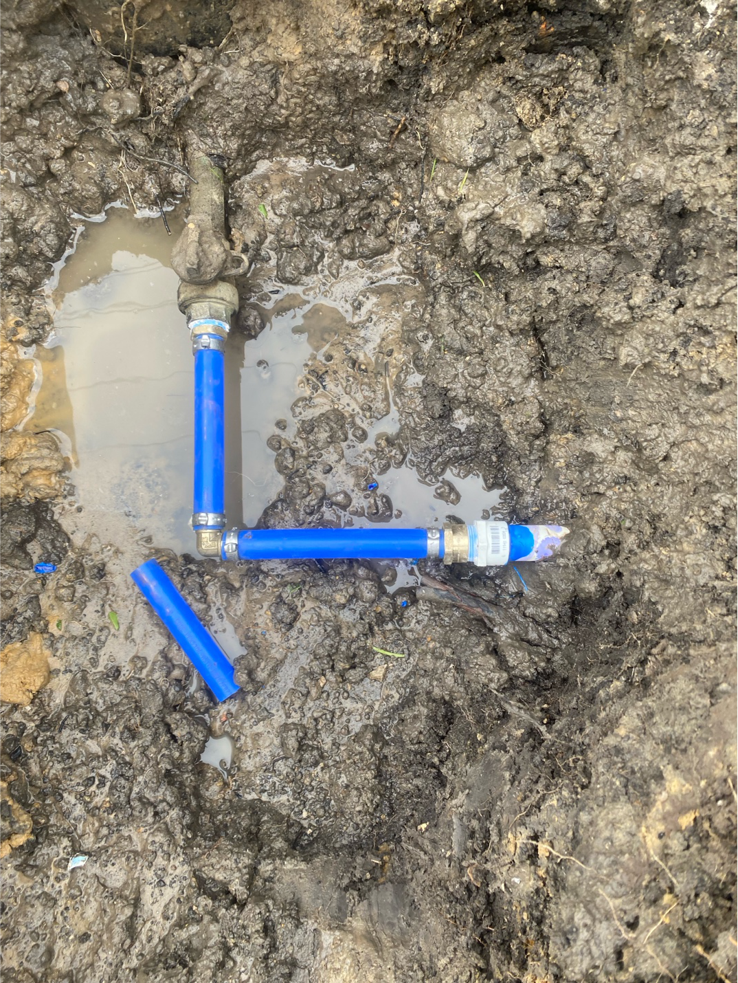 A repaired water line with clean connections and sealed joints.