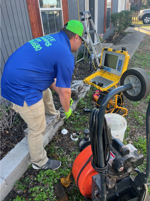A plumber using a drain inspection camera before jetter cleaning a residential sewer line.