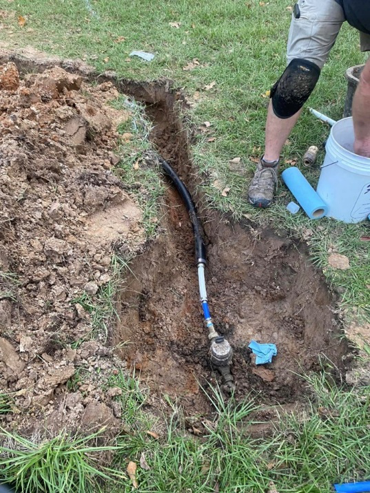 Exposed underground water line and meter connection during plumbing work